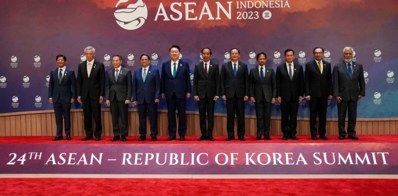 A group of ASEAN leaders stand in front of the logo for the 2023 ASEAN Summit.