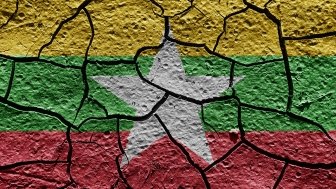 The flag of Myanmar painted on cracked pavement