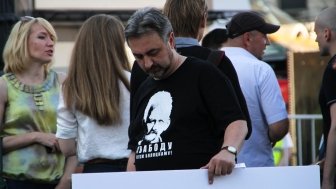 Man holding sign with shirt supporting Ales Bialiatski