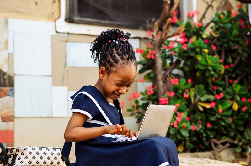 Young African girl working on a laptop computer.