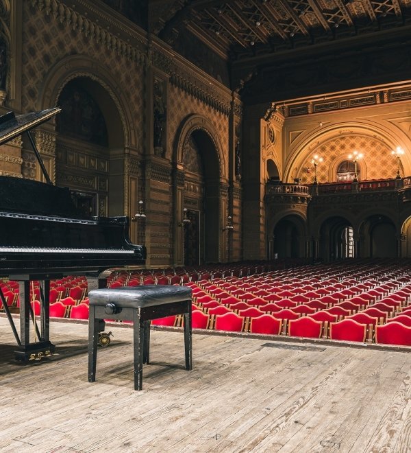 Image of piano on concert hall stage 