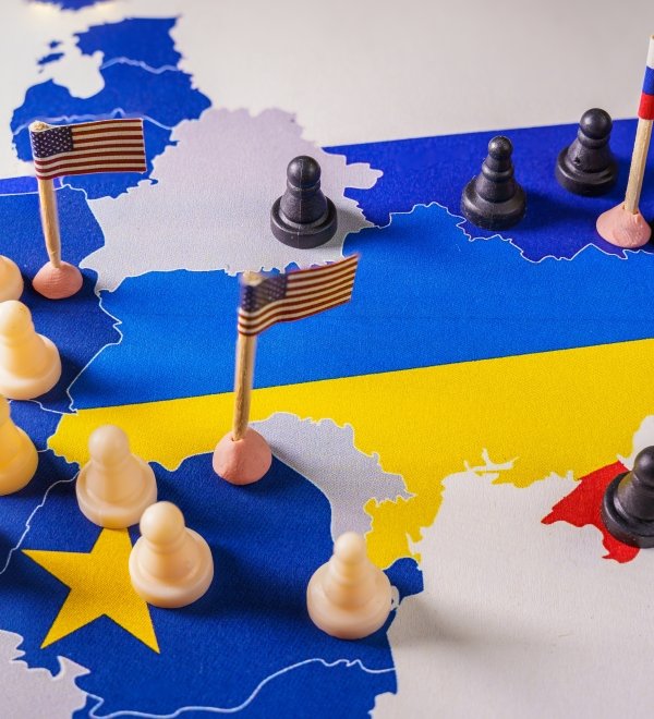 EU, USA and Russian flags with chess pieces symbolizing the conflict and control of Ukraine