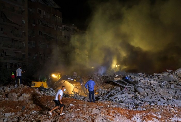 27 September 2024, Lebanon, Beirut: Rescue workers gather at the site of a massive Israeli air attack on pro-Iranian Hezbollah headquarters in the southern suburbs of Beirut