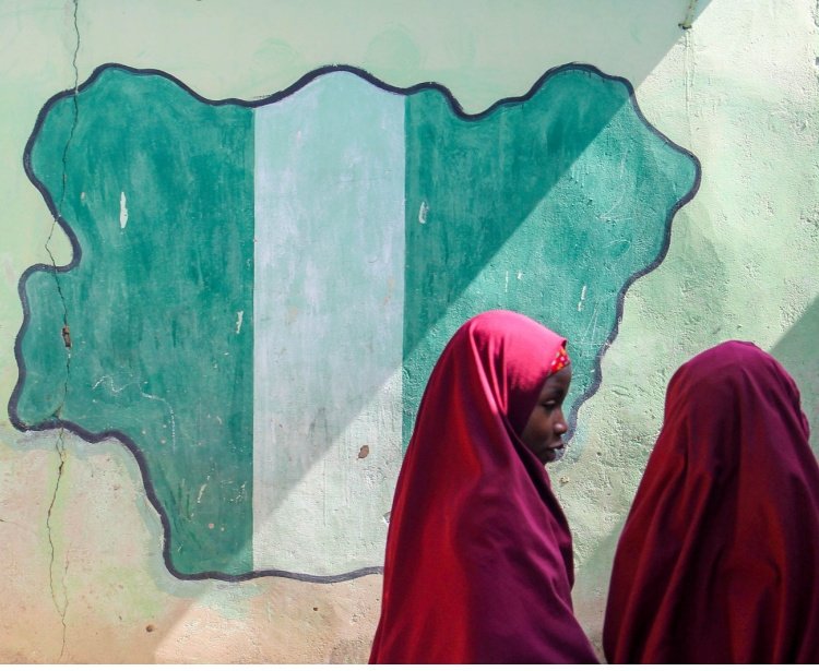 Girl students pass a classroom with the map and flag of Nigeria painted on it, at Success Private School, one of the first schools attacked by Boko Haram in '09.