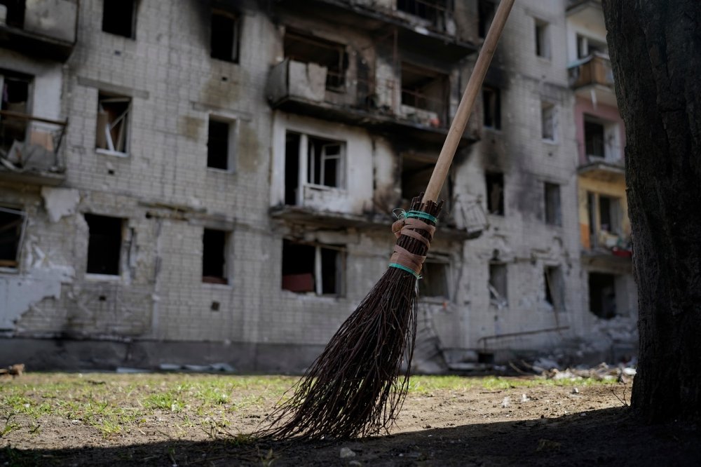 Broom in foreground, bombed building in background