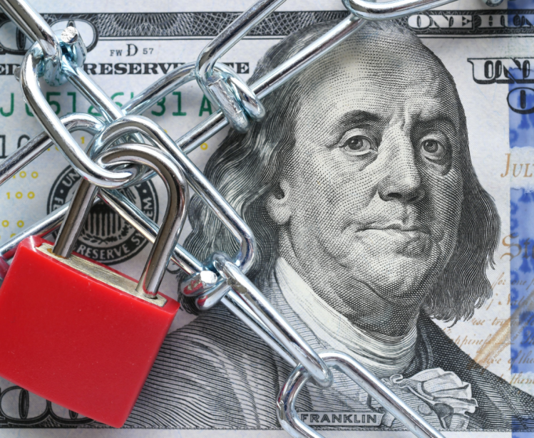 Photo of a lock and chain across a $100 bill