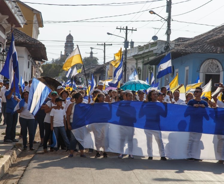 Granada, Nicaragua - May 29, 2018: peaceful protests in Granada Nicaragua for reform of INSS, people flying the Nicaraguan flag