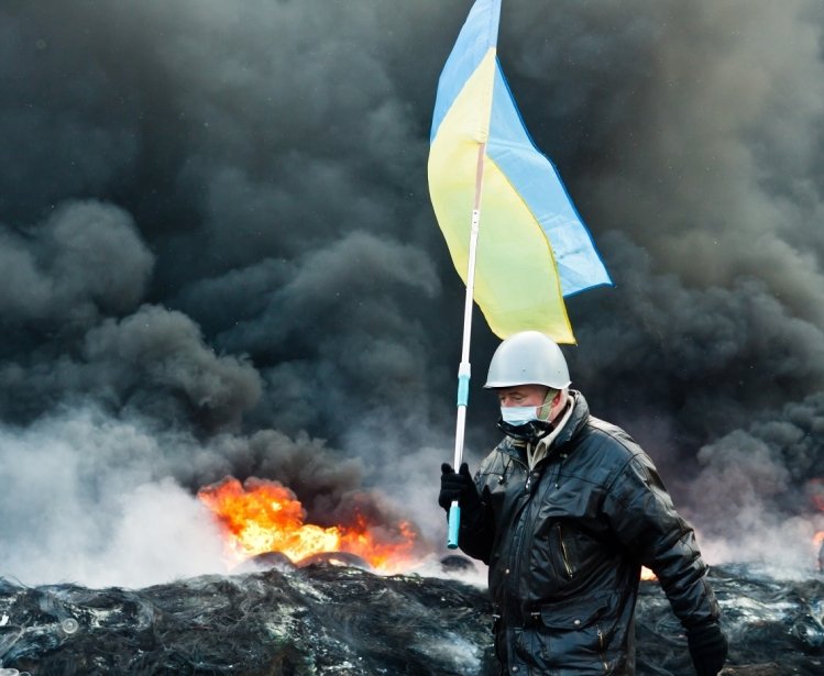 Unknown demonstrator carrying a Ukrainian flag at the Independence square in Kyiv during Euromaidan