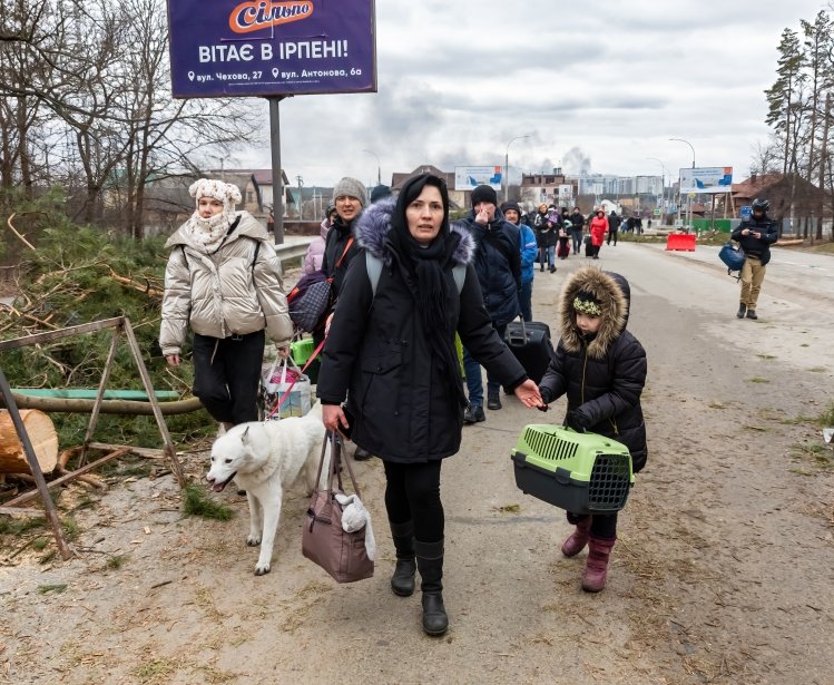 IRPIN, UKRAINE - Mar. 05, 2022: War in Ukraine. Women, old people and children evacuated from Irpin town was transferd to Kyiv by Kyiv territorial defense battalion. War refugees in Ukrain