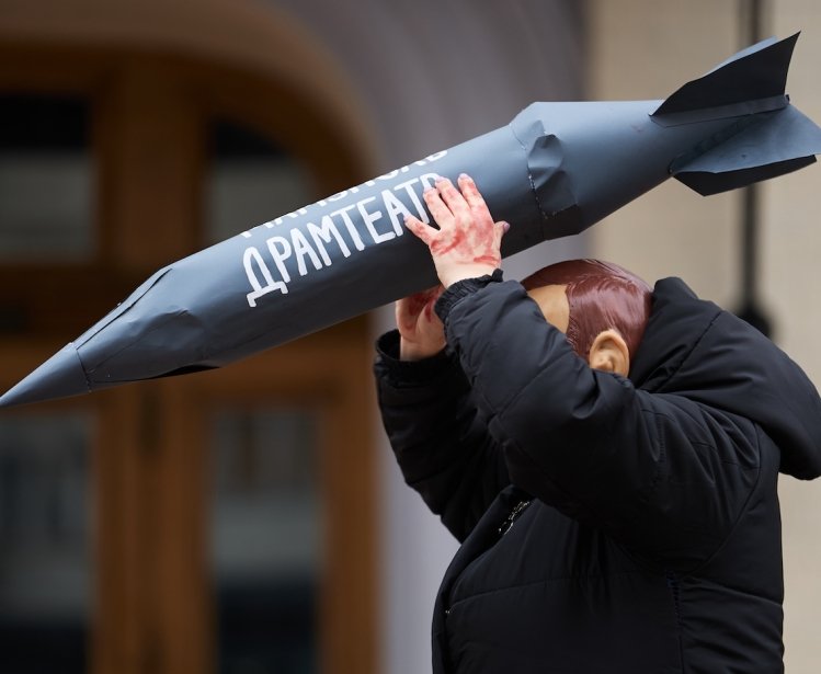 Actor in mask of vladimir putin attacks civilians with the rocket during the art performance dedicated to the anniversary of russian airstrike on Mariupol Drama Theatre in 2022.