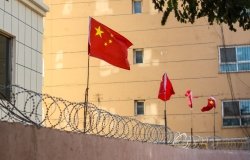 Chinese flags on barbed wired wall in Kashgar (Kashi), Xinjiang, China.