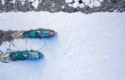 Ice breakers crush through the ice in an aerial shot