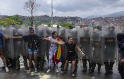 Residents try to block a street to protest the official results the day after the presidential election as National Guards work to remove them in Caracas, Venezuela, Monday, July 29, 2024. (AP Photo/Fernando Vergara)