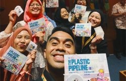 Indonesian students and educators taking a selfie with the plastic pipeline brochures and sticker