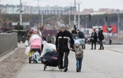 Group with children carrying items down a road